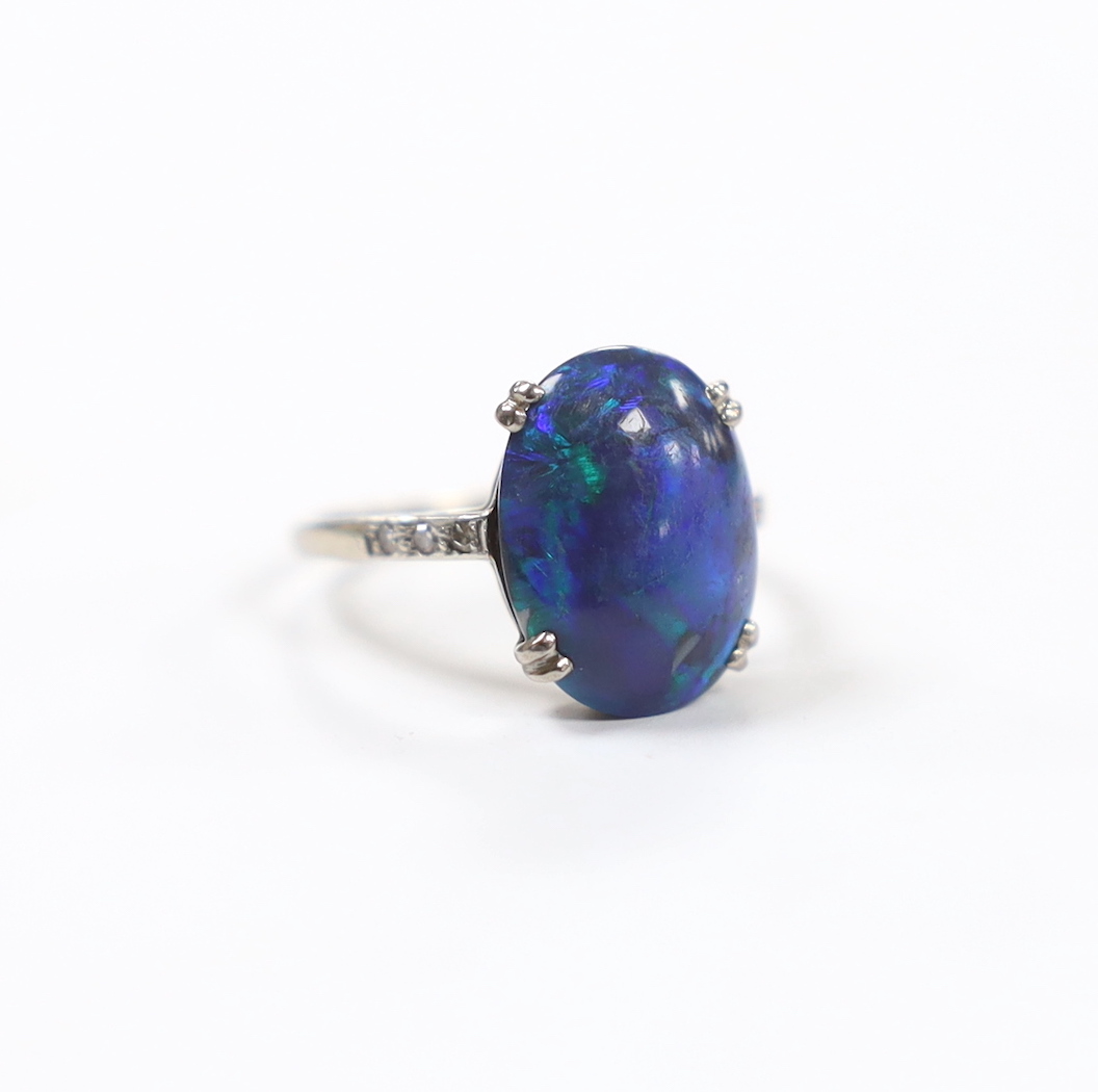 An 18ct, plat and single stone cabochon black opal set ring, with six stone diamond chip set shoulders, size K, gross weight 2.6 grams.